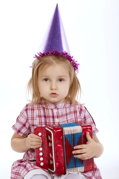 Flicka med födelsedag cap spelar dragspel — Stockfoto