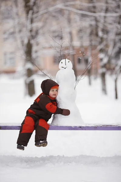 Ragazzino con pupazzo di neve — Foto Stock