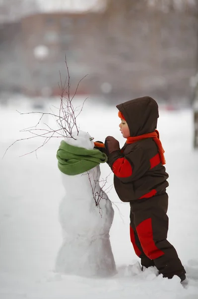 Ragazzino con pupazzo di neve — Foto Stock