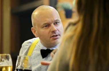 Lokantada masanın karşısındaki kadınla konuşan cesur ve yakışıklı bir adam.