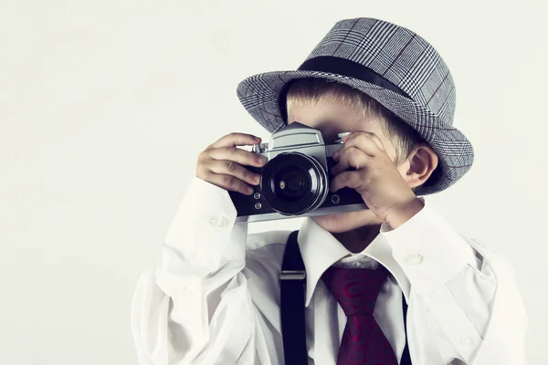Jongen speelt met een oude camera als fotograaf — Stockfoto