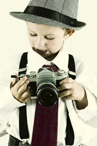 Kleiner Junge spielt mit einer alten Kamera, um Fotograf zu werden — Stockfoto