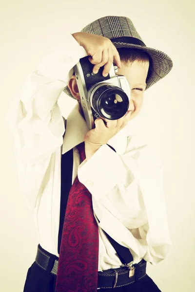 Kleiner Junge spielt mit einer alten Kamera, um Fotograf zu werden — Stockfoto