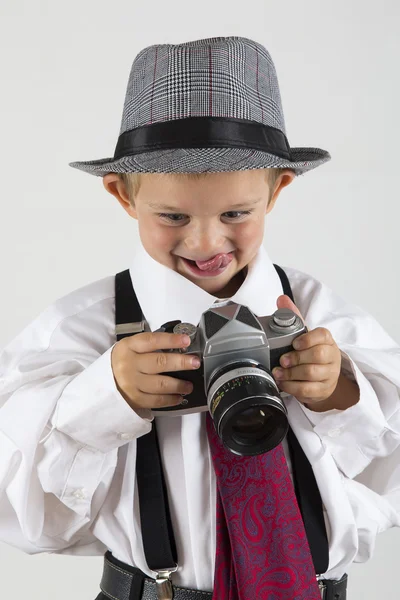 Jongen speelt met een oude camera als fotograaf — Stockfoto