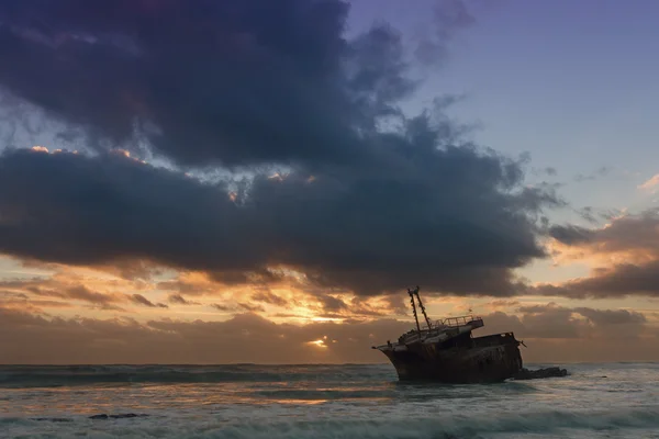Старый кораблекрушение длительное воздействие на скалах заката — стоковое фото