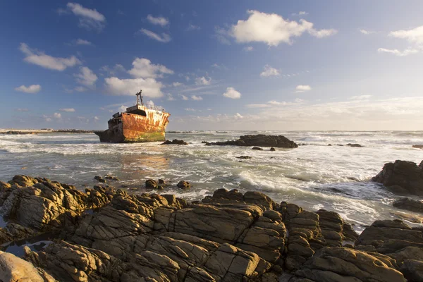 Old shipwreck long exposure on the rocks sunset — Stock Photo, Image