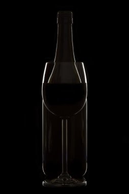 Şarap kadehi ve şişe üzerinde siyah arka plan aydınlatma jant
