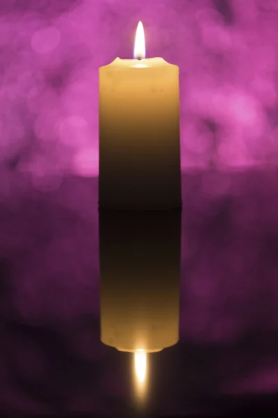Candle skjuten i studio med violett bokeh ljus i bakgrunden — Stockfoto