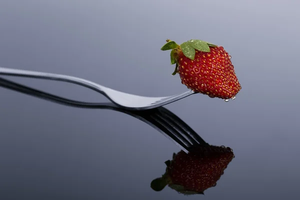 Red and wet strawberry on a form with reflection on shiny surfac — Stock Photo, Image