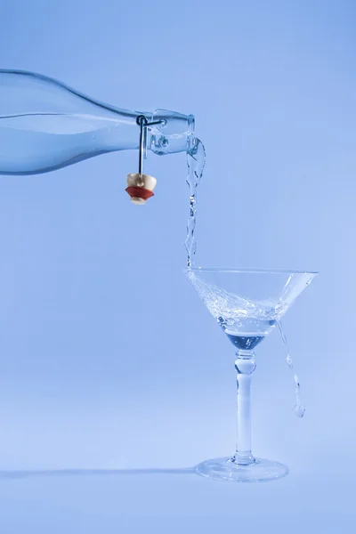 Clear water pour out of bottle splash into glass and spill with — Stock Photo, Image