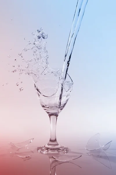 Clear water pour out of bottle splash into glass and spill with — Stock Photo, Image