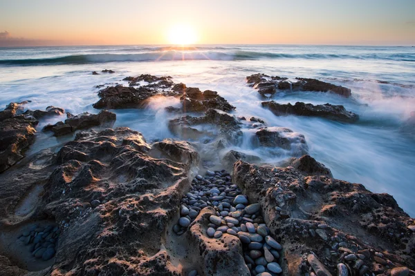 Early morning landscape of ocean over rocky shore and glowing su — Stock Photo, Image