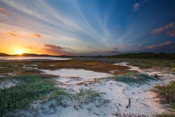 Cloudy sunrise over a quiet lagoon with cloud patterns and orang — Stock Photo, Image