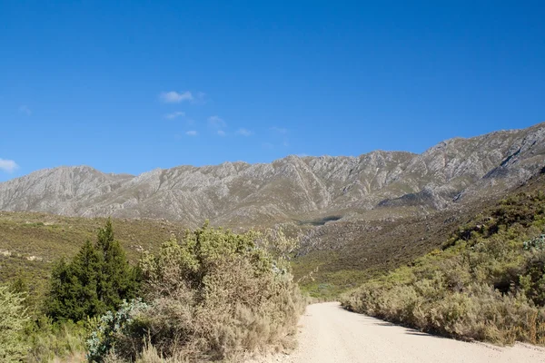 Camino de tierra que conduce sobre el paso de alta montaña durante el día —  Fotos de Stock