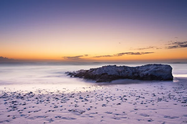 Late evening landscape of ocean over rocky shore with clouds blo — Stock Photo, Image