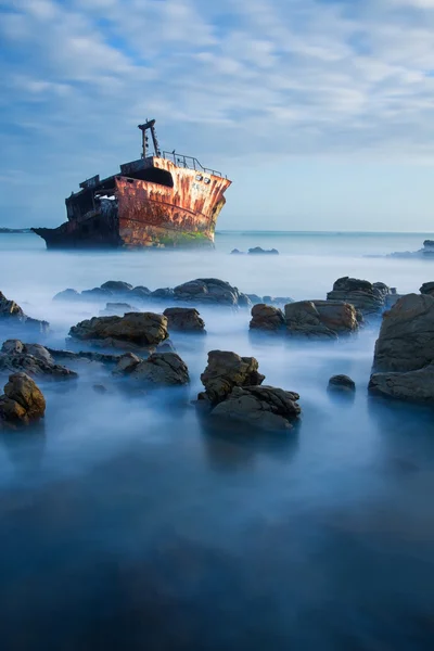 Altes Schiffswrack lange Belichtung auf Felsen bei Sonnenuntergang — Stockfoto