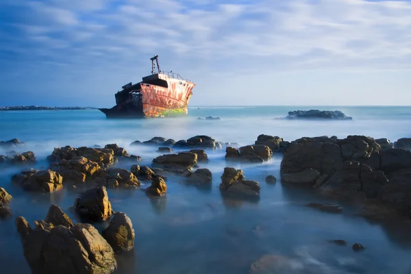 Старая кораблекрушение длительное воздействие на скалах на закате — стоковое фото