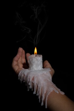 Open hand holding candle stick with wax flowing down the arm clipart