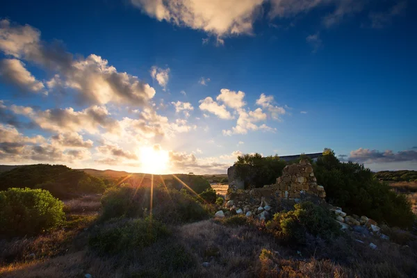 Old small deserted house in field with cloud sunset landscape