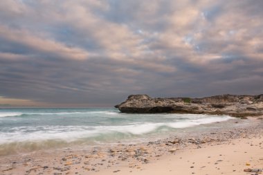 Geç akşam manzara okyanus üzerinde kayalık sahil ağır bulutlar bl
