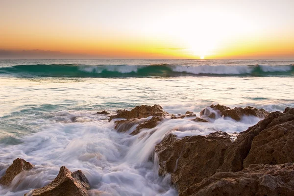 Early morning landscape of ocean over rocky shore and glowing su — Stock Photo, Image