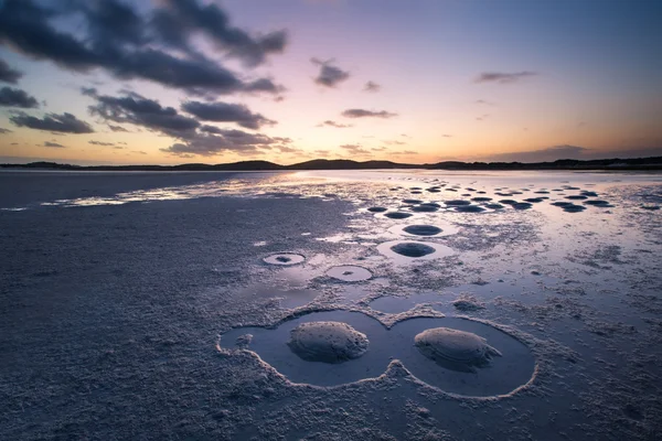 Bewölkter Sonnenuntergang über einer ruhigen Lagune mit interessanten Mustern aus — Stockfoto