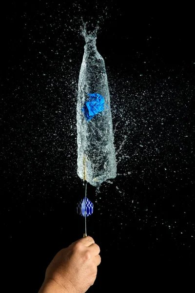Balloon filled with water is popped with dart to make a mess — Stock Photo, Image
