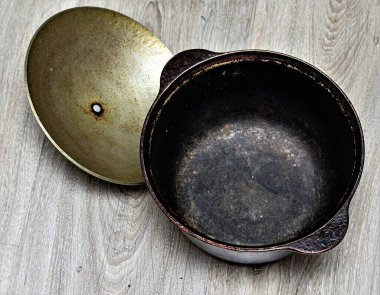 Ahşap arka planda eski dökme demir kazan.