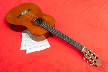 Gitar, kırmızı zemin üzerine kağıt notlar.