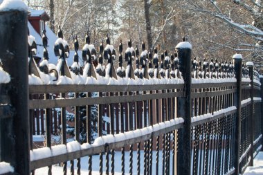 Kışın karda, arka planda demir çit döşedim..