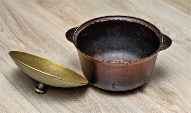 Ahşap arka planda eski dökme demir kazan.