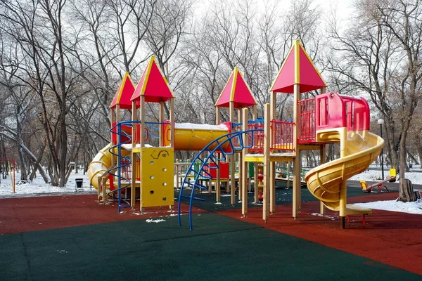冬天公园里有滑梯和秋千的儿童木制游乐场 — 图库照片