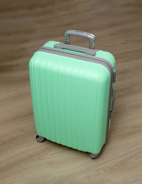 床に薄緑色のプラスチック製のスーツケース — ストック写真