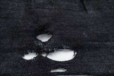 Siyah eski kumaşta yırtık çizikler var..