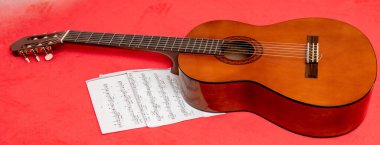 Gitar, kırmızı zemin üzerine kağıt notlar.
