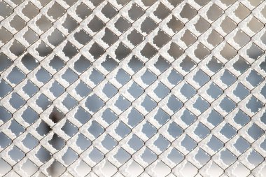 Kış arka planında karda örülmüş metal örgüler..