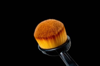 Siyah arkaplanda makyaj fırçaları.