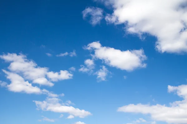 Pluizige wolken in de blauwe lucht — Stockfoto