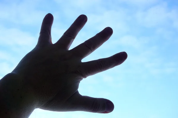 Mão humana no fundo do céu — Fotografia de Stock