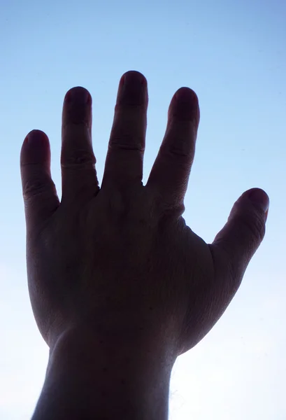 Mão humana no fundo do céu — Fotografia de Stock