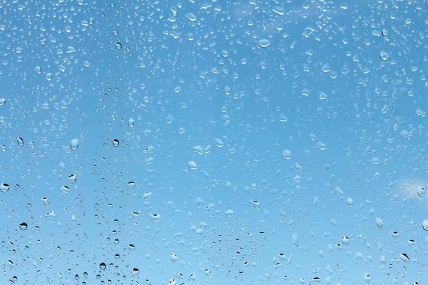 Gotas de agua sobre vidrio contra — Foto de Stock