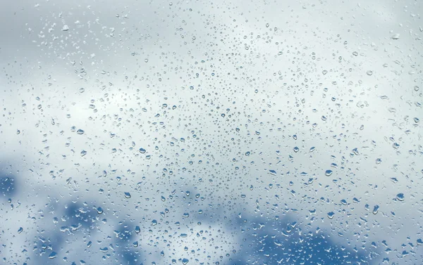 Gotas de água em vidro contra o céu azul — Fotografia de Stock