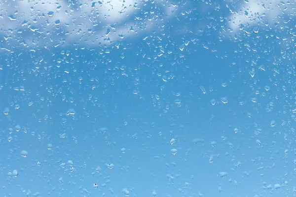 Краплі води на склі проти блакитного неба — стокове фото