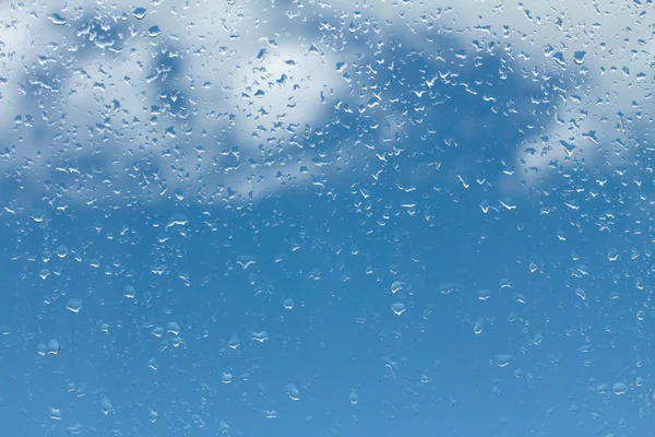 Vatten droppar på glas mot blå himmel — Stockfoto