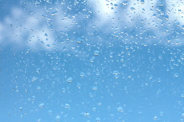 Water drops on glass against blue sky — Stock Photo, Image