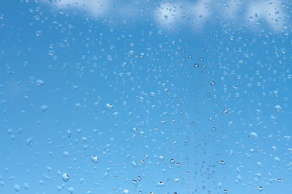 青い空に向かってガラスに水が落ちる — ストック写真
