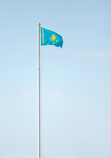 Cazaquistão agitando bandeira contra o céu azul — Fotografia de Stock