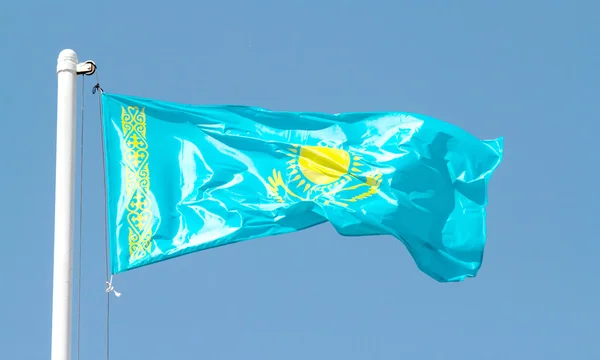 Cazaquistão agitando bandeira contra o céu azul — Fotografia de Stock