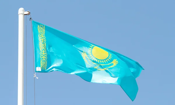 Kazakhstan waving flag against blue sky — Stock Photo, Image