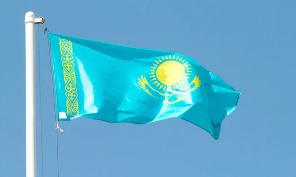 Cazaquistão agitando bandeira contra o céu azul — Fotografia de Stock